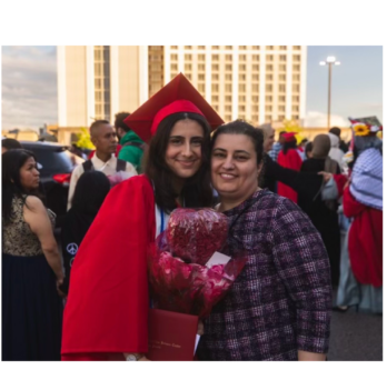 Lauren, dressed in red cap and gown, smiles while embracing her mother.
                  